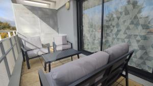 un soggiorno con divano e una sedia sul balcone di Appartement proche de La Rochelle centre ad Aytré