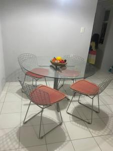 a table and chairs with a bowl of fruit on it at Flat Quintal293 in Recife