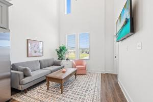 ein Wohnzimmer mit Sofa und Tisch in der Unterkunft NEW Vermillion House KING Bd Cajun Luxury Book Now in Lafayette