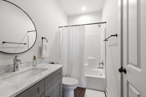 ein Badezimmer mit Waschbecken, Toilette und Spiegel in der Unterkunft NEW Vermillion House KING Bd Cajun Luxury Book Now in Lafayette + 15 Fotos