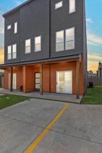 ein schwarzes Haus mit zwei Garagentüren und einer Einfahrt in der Unterkunft NEW Vermillion House KING Bd Cajun Luxury Book Now in Lafayette