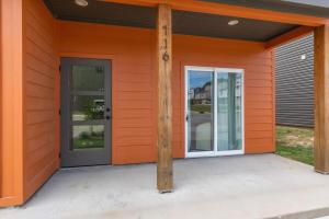 ein orangefarbenes Haus mit einer Tür und einer Stange in der Unterkunft NEW Vermillion House KING Bd Cajun Luxury Book Now in Lafayette