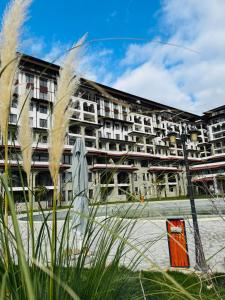 an apartment building with tall grass in front of it at SeaView Etara IV Apartment in Sveti Vlas in Sveti Vlas
