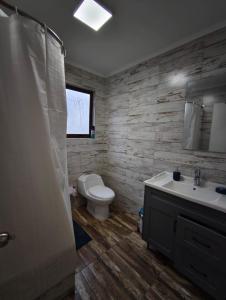 a bathroom with a toilet and a sink at Bosque marino in Pichilemu +57 photos