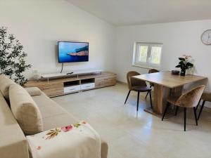 a living room with a couch and a table at Apartment Aurora in Ankaran
