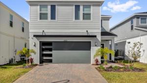 a gray house with a garage and a driveway at Family Home w Cinema, Pool & BBQ Clermont in Orlando