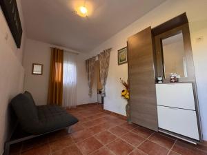 a living room with a chair and a mirror at Apartman Nonno Božo 1 in Fažana