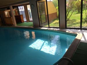 a swimming pool in a house with windows at Grande Chambre Climatisée 1 à 4 couchages in Wasselonne
