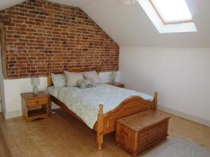 a bedroom with a bed and a brick wall at Prince Rupert's cottage with garden in Sibbertoft +13 photos