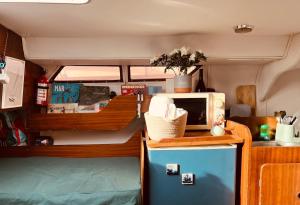 a small kitchen with a microwave and a refrigerator at Bacus - Your Floating Hideaway in Lisbon in Lisbon