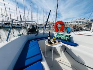 a boat with a table and a bottle of wine on it at Bacus - Your Floating Hideaway in Lisbon in Lisbon