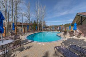 una piscina con sedie, un tavolo e ombrelloni blu di Cozy Condo for 8 Hot-Tub HOA Amenities Walk to Beach Close to Slopes a Tahoe City