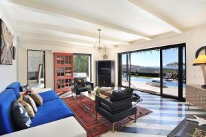 un soggiorno con un divano blu e un tavolo di Villa Bohemia Puerto Los Cabos by The Agency Baja a San José del Cabo