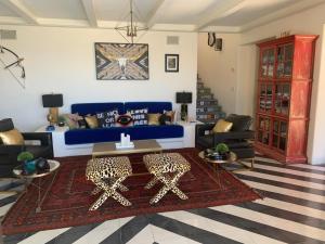 un soggiorno con un divano blu e un tavolo di Villa Bohemia Puerto Los Cabos by The Agency Baja a San José del Cabo