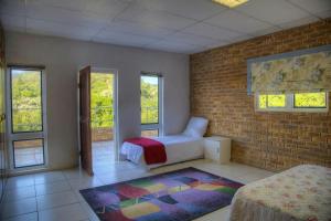 a bedroom with a bed and a brick wall at Mgwalana River Lodge in Mgwalana Mouth