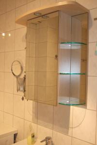 ein Badezimmer mit einem Glasschrank über einem Waschbecken in der Unterkunft Ferienwohnung Utz in Zwiesel