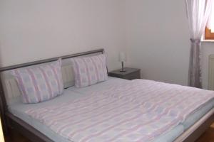 ein Bett mit rosa und weißen Kissen im Schlafzimmer in der Unterkunft Ferienwohnung Utz in Zwiesel