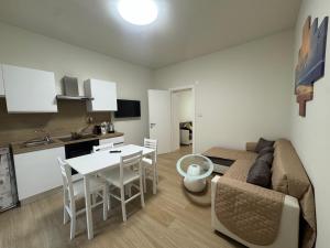 un soggiorno con un divano, un tavolo e una cucina di B&B Sofia Home a Catania