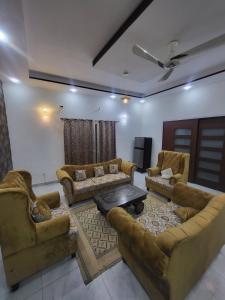 ein Wohnzimmer mit Sofas und einem Tisch in der Unterkunft Paradise in Karatschi