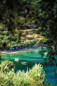 two boats in the water next to a beach at Marathias beach Miss Asimenia in Milína +43 photos