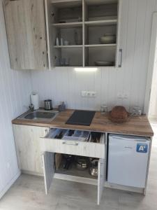 a kitchen with a sink and a wooden counter top at Domki PrzystańTu in Jastarnia