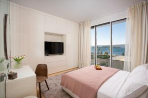 a bedroom with a bed and a large window at Villa Valea in Turanj