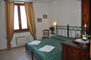 a bedroom with a green bed with two towels on it at Agriturismo Ai Piacentini in Santo Stefano Belbo