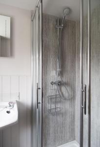 La salle de bains est pourvue d'une douche et d'un lavabo. dans l'établissement No33 HILLVIEW LODGE BOUTIQUE COTTAGE, à Brancaster