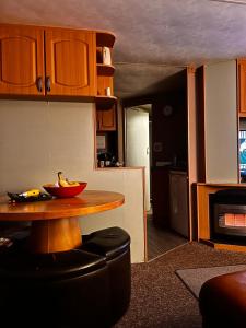 a kitchen with a table with a bowl of bananas on it at Kings caravan park A-27 in Skegness