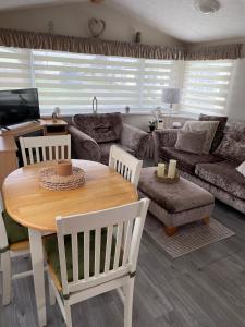 a living room with a table and a couch at Meadow & Tide in Saint Merryn +9 photos