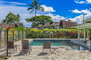 プリンスビルにあるPuamana 6Bの椅子とテーブル、フェンス付きのプール