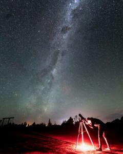 a man looking at the stars in the night sky at Te Mahuru Retreat in Kaikoura