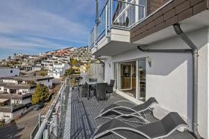 a balcony with chairs and tables on a building at Koblenz Rheinblick Penthouse in Vallendar