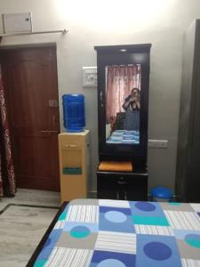 Habitación con cama y espejo con una persona. en King Size Bed Room with Toilet, en Hyderabad
