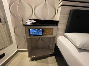 CarapicuíbaにあるHotel Estrela Carapicuíbaのベッド横の夜間用時計