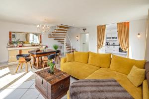 a living room with a yellow couch and a table at Koblenz Rheinblick Penthouse in Vallendar