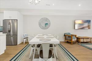 a white kitchen with a table and a refrigerator at Spacious Newly Built Townhouse 2 blocks to Beach in Ventnor City