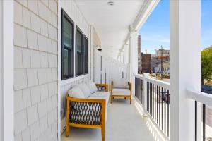 a balcony with two chairs and a bench on it at Spacious Newly Built Townhouse 2 blocks to Beach in Ventnor City +50 photos
