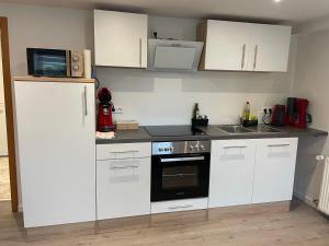 a kitchen with white cabinets and a microwave at Ferienwohnung in Kuppenheim für 1 bis 2 Personen in Kuppenheim
