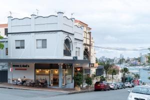 a white building on the corner of a street at The Bay Retreat - Neutral Bay in Sydney