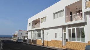a white building on the side of a street at Casa Piedra Playa in El Cotillo