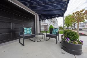 eine Terrasse mit zwei Stühlen und einer Aortenanpflanze in der Unterkunft Brand New Ground Floor near Downtown Ocean City in Ocean City