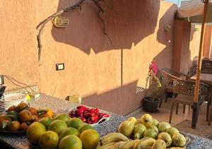 a table with a bunch of fruits and vegetables on it at Pyramids Road Guest House in Cairo +30 photos