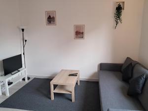 a living room with a couch and a coffee table at Le calme à 2 pas du centre - F2 - 4 couchages in Belfort