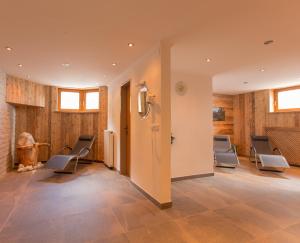 a waiting room with chairs and a wall with wooden walls at Hotel Gasthof Edelweiß in Sankt Jakob in Defereggen