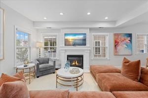 Luxurious OC Single Family Home with Hot Tub في أوشن سيتي: غرفة معيشة مع أريكة ومدفأة