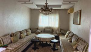 a living room with a couch and a chandelier at appartement a louer in Beni Mellal