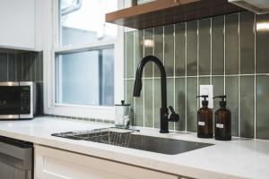 a kitchen with a sink with two bottles of wine at City Oasis - Entire Designer House - Near Disneyland in Hacienda Heights +68 photos