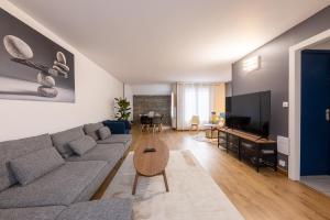 una sala de estar con un sofá y una mesa en Nice house close to Disney 12 people, en Champs-Sur-Marne