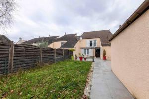 una casa con una valla y una acera en un patio en Nice house close to Disney 12 people, en Champs-Sur-Marne